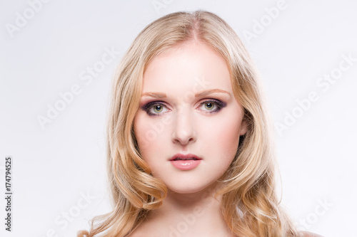 Portrait einer hübschen blonden jungen Frau vor weissem Hintergrund