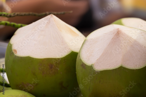 Fresh fragrant coconuts in boat on flea market background, Most pure drink of all the juices photo