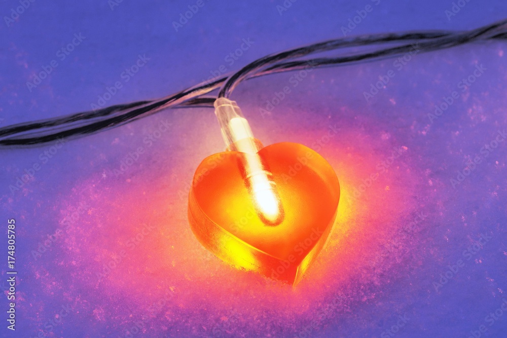 Lit heart-shaped fairy lights in the snow Lit heart-shaped fairy lights in the snow