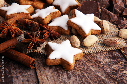 Christmas cookies and spices on brown wooden background.