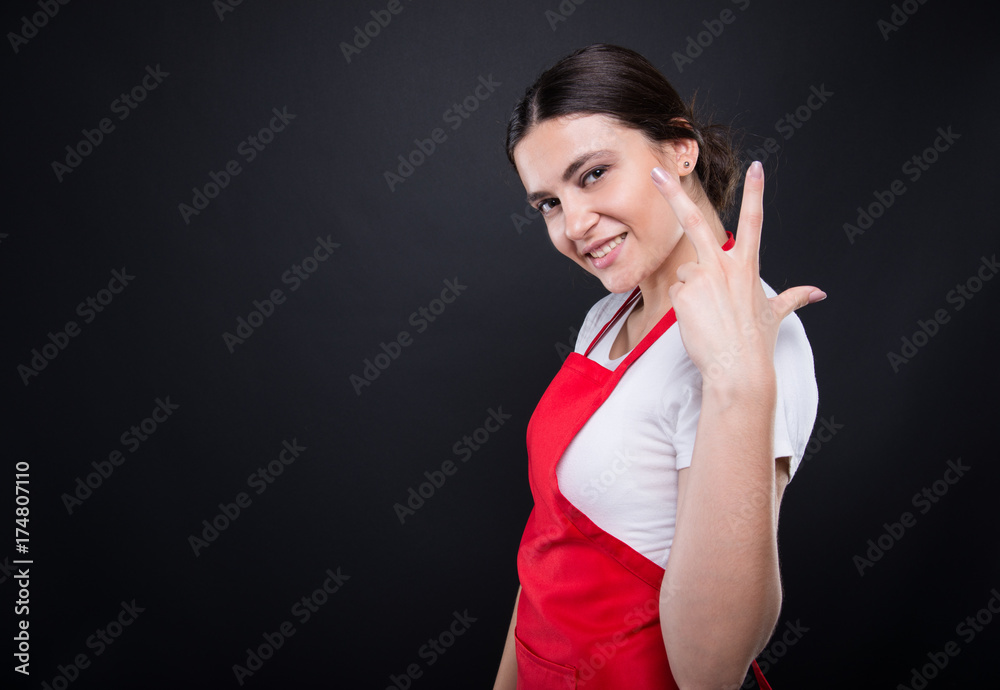 Cheerful seller rising three fingers Cheerful seller rising three fingers