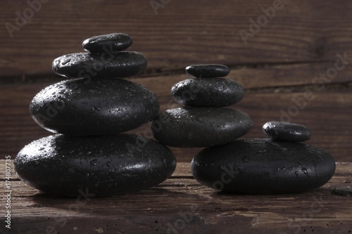 Hot stone massage stones on a wooden beam