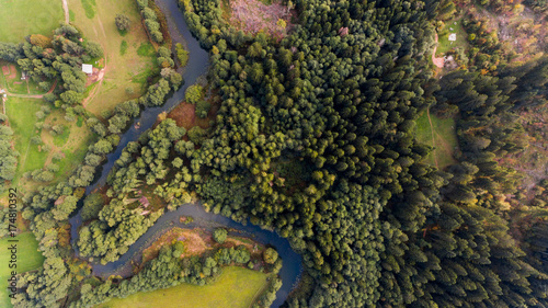 Aerial view of river bend through forest.