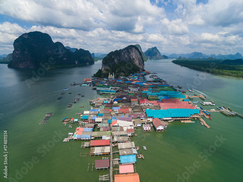 Top view of fishing village Ko Panyi (Koh Panyee) in Phang Nga Bay, Thailand. Aerial top view of a muslim fisherman village with houses on pillars in the Andaman sea. Phuket, Phang Nga Bay, Thailand photo