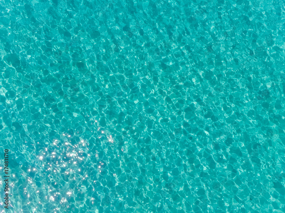 Aerial top view of sea surface. Transparent turquoise ocean water surface from drone.