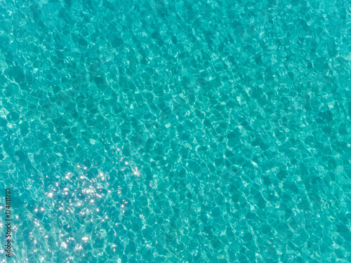 Aerial top view of sea surface. Transparent turquoise ocean water surface from drone.