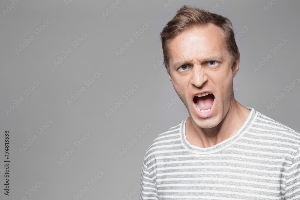 Emotional man on grey background Emotional man on grey background