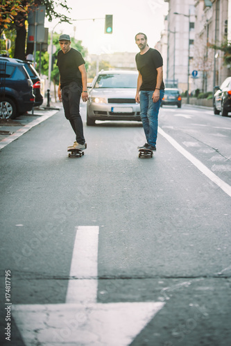 Wallpaper Mural Two pro skateboard rider ride skate through cars on street Torontodigital.ca