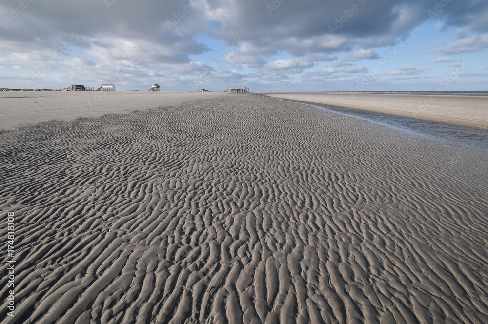 Φωτογραφία Beach of Sankt Peter-Ording in the morning sun during low tide with stilt houses