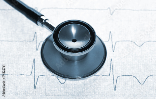Close up view of stethoscope on electrocardiogram background.