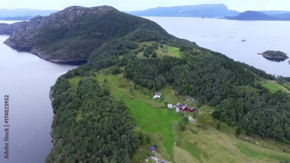 View from above island with green dense forest and blue sea. Magnificent seascape of Norwegian islands. Clean lake, river with clear water. Flight over sea and great island, mountains in background View from above island with green dense forest and blue sea. Magnificent seascape of Norwegian islands. Clean lake, river with clear water. Flight over sea and great island, mountains in background