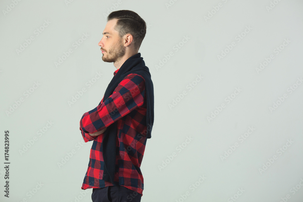 handsome young guy in checkered shirt in studio on wall background handsome young guy in checkered shirt in studio on wall background
