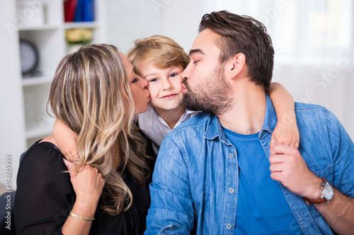 family portrait - young couple kissing little son