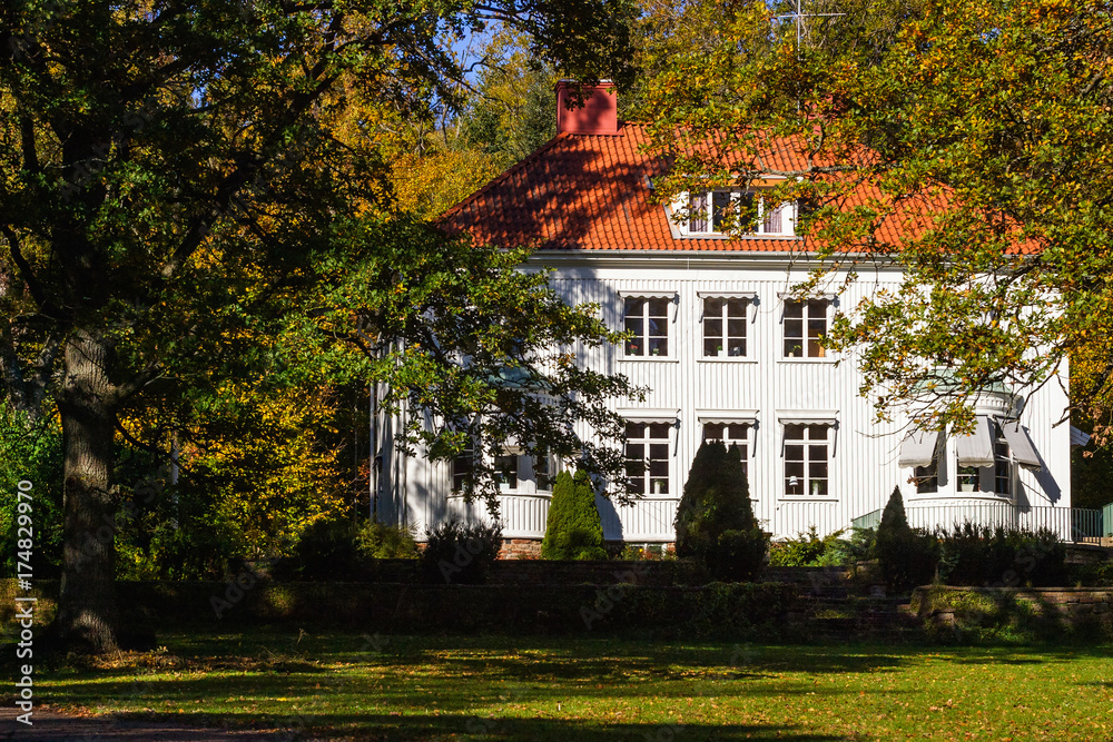 White residential house with a garden in autumn White residential house with a garden in autumn