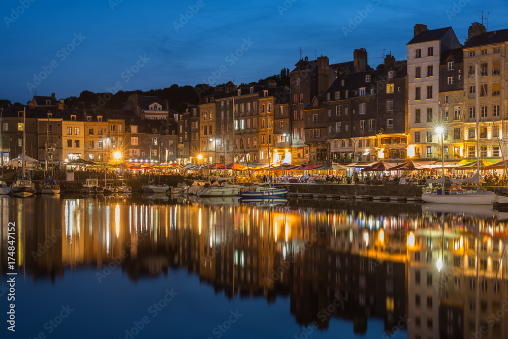 Harbor Honfleur at night with ships and restaurants, France