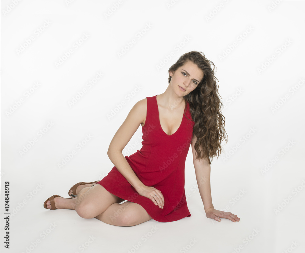 Attractive young woman with long brown hair in red mini dress on white background Attractive young woman with long brown hair in red mini dress on white background