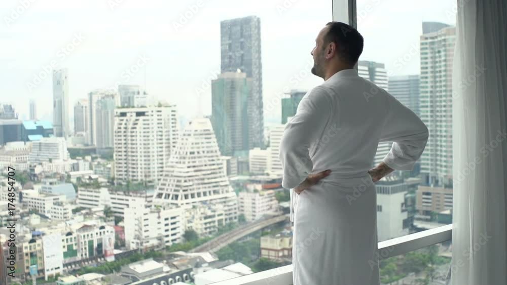 Young man in bathrobe admire view form window at home
Young man in bathrobe admire view form window at home