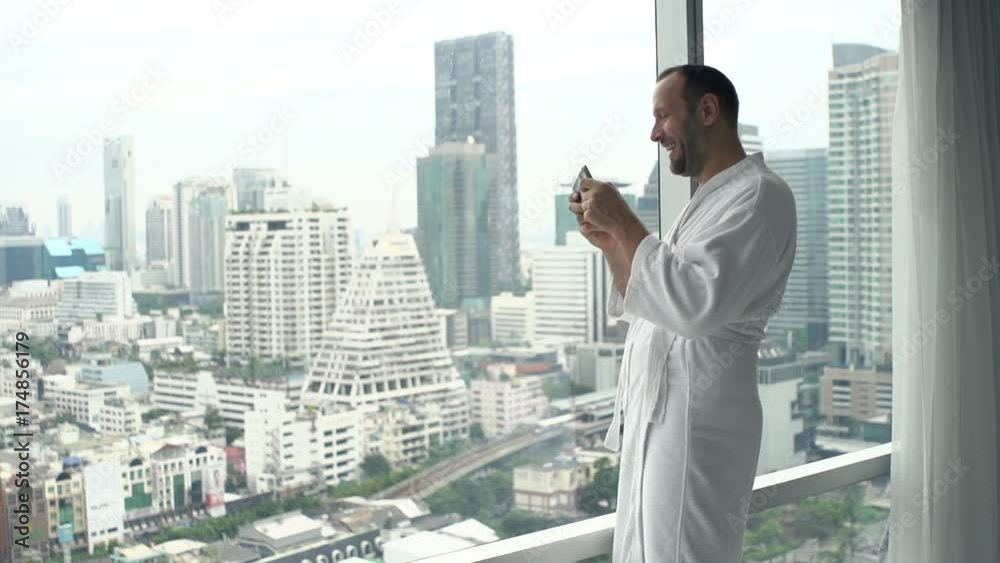 Man playing game on smartphone standing by window at home
Man playing game on smartphone standing by window at home