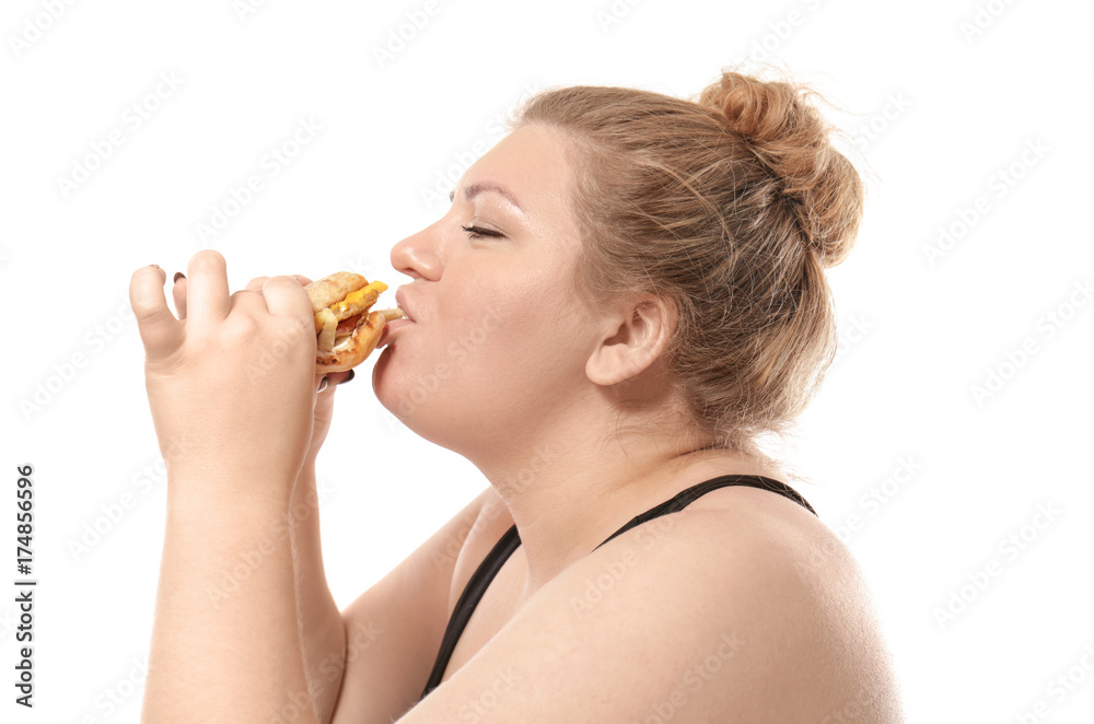 Overweight young woman eating burger on white background Overweight young woman eating burger on white background