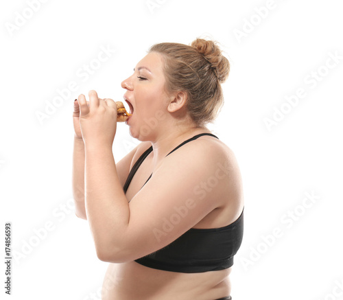 Overweight young woman eating burger on white background