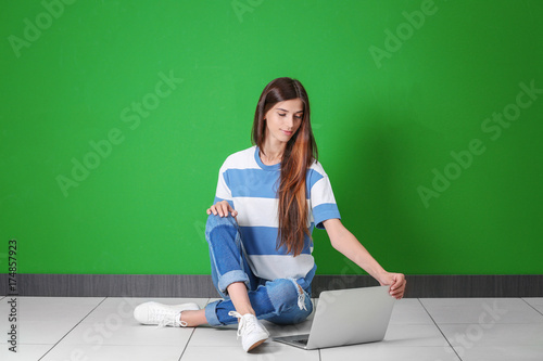 Young woman with laptop nea...