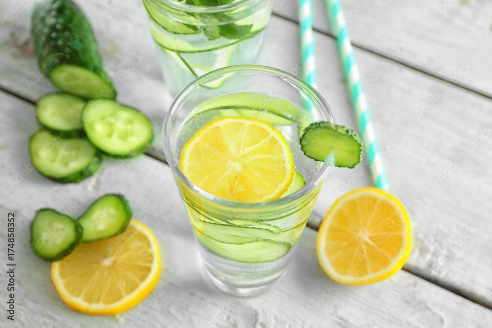 Glass of fresh cucumber water with lemon on table Glass of fresh cucumber water with lemon on table