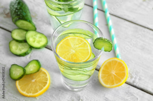 Glass of fresh cucumber water with lemon on table © Africa Studio