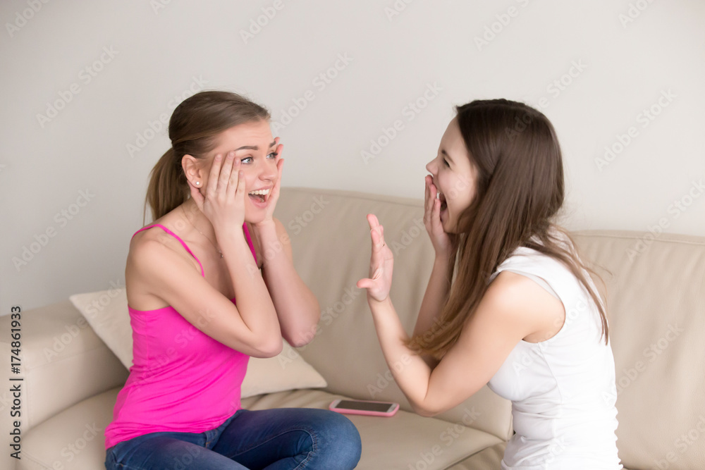 Young happy girl screaming in joy while showing her precious expensive diamond ring to surprised girlfriend. Best friends celebrate one of them getting engaged. Girl received proposal, romantic gift. Young happy girl screaming in joy while showing her precious expensive diamond ring to surprised girlfriend. Best friends celebrate one of them getting engaged. Girl received proposal, romantic gift.