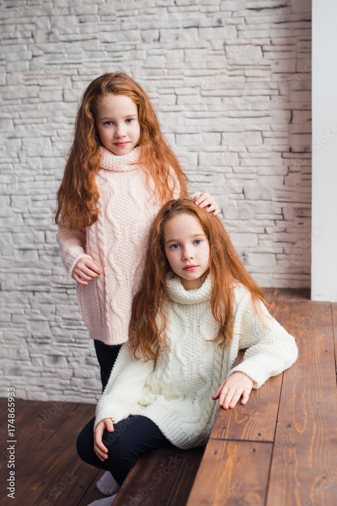 the red-haired twins in warm knitted sweaters