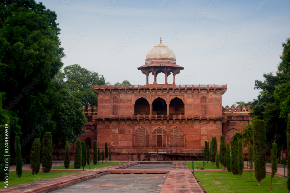 Sand stone building with arched doorways and a dome situated in a beautiful garden. The beauty and perfection is typical of mughal architecture. Many such buildings are part of the Taj Mahal complex
