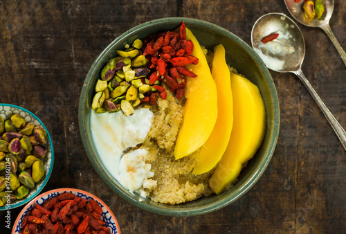 Quinoa porridge with mango, pistachio nuts, goji berries and honey yogurt
