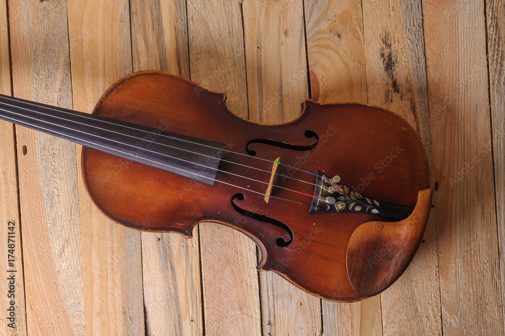 one violin image .old brown stringed wooden instrument isolated on the wood background one violin image .old brown stringed wooden instrument isolated on the wood background