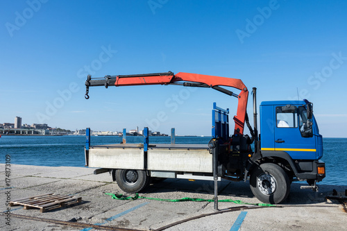 Truck cranes in Shipyards harbor of Trieste in clear weather on a background of blue sky