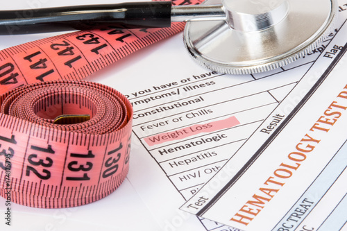 Photo idea of weight loss as symptom or sign of cancer endocrine diseases. Highlighted  during doctor consultations title weight loss symptom on patient history next to stethoscope and measuring tape photo