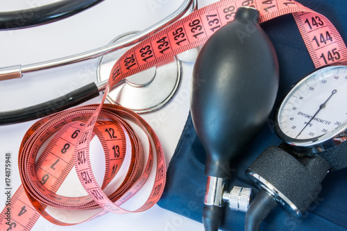 Weight gain or loss and high or low blood pressure concept. Measuring tape, stethoscope and sphygmomanometer. Effect of obesity, increased body weight or slimming on indicators of human blood pressure photo