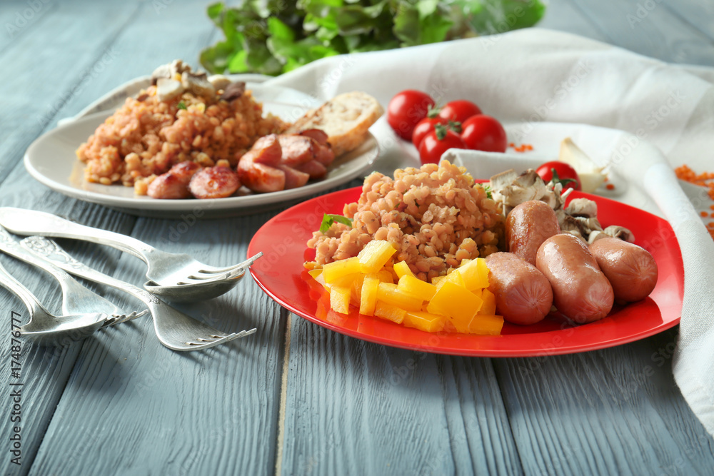 Plate with tasty lentils, sausages and vegetables on table Plate with tasty lentils, sausages and vegetables on table