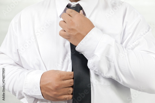businessman in white shirt taking off neck tie