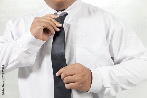 businessman in white shirt taking off neck tie