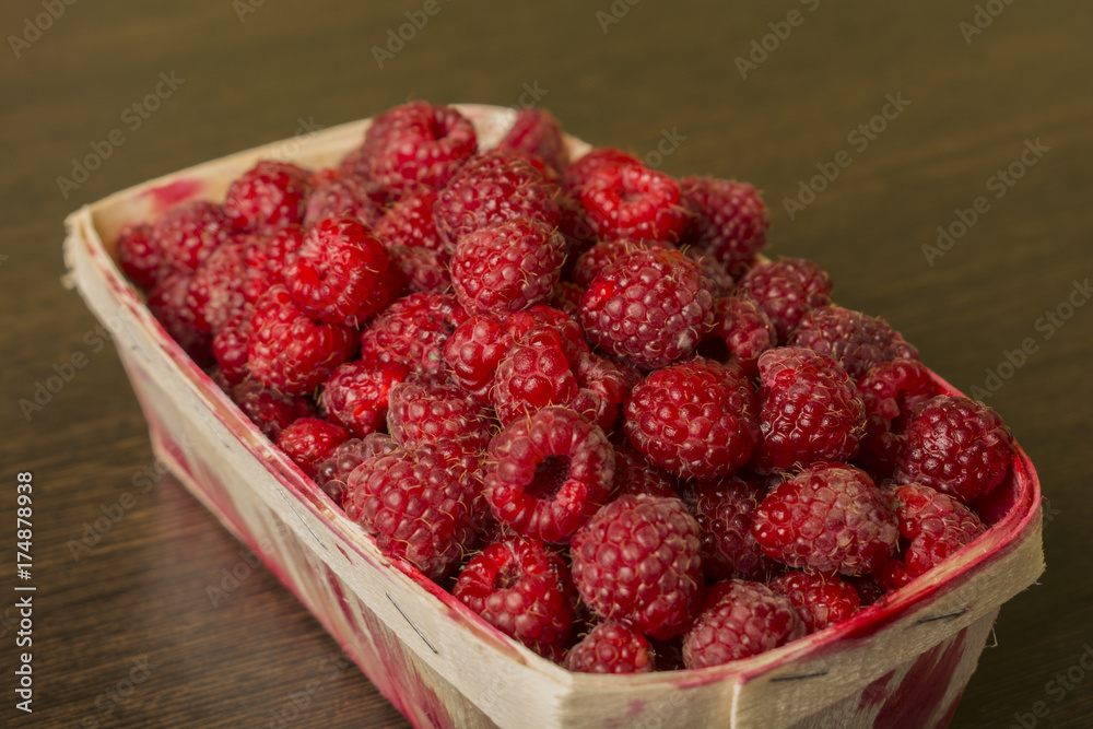 raspberry in a basket on a wooden background raspberry in a basket on a wooden background