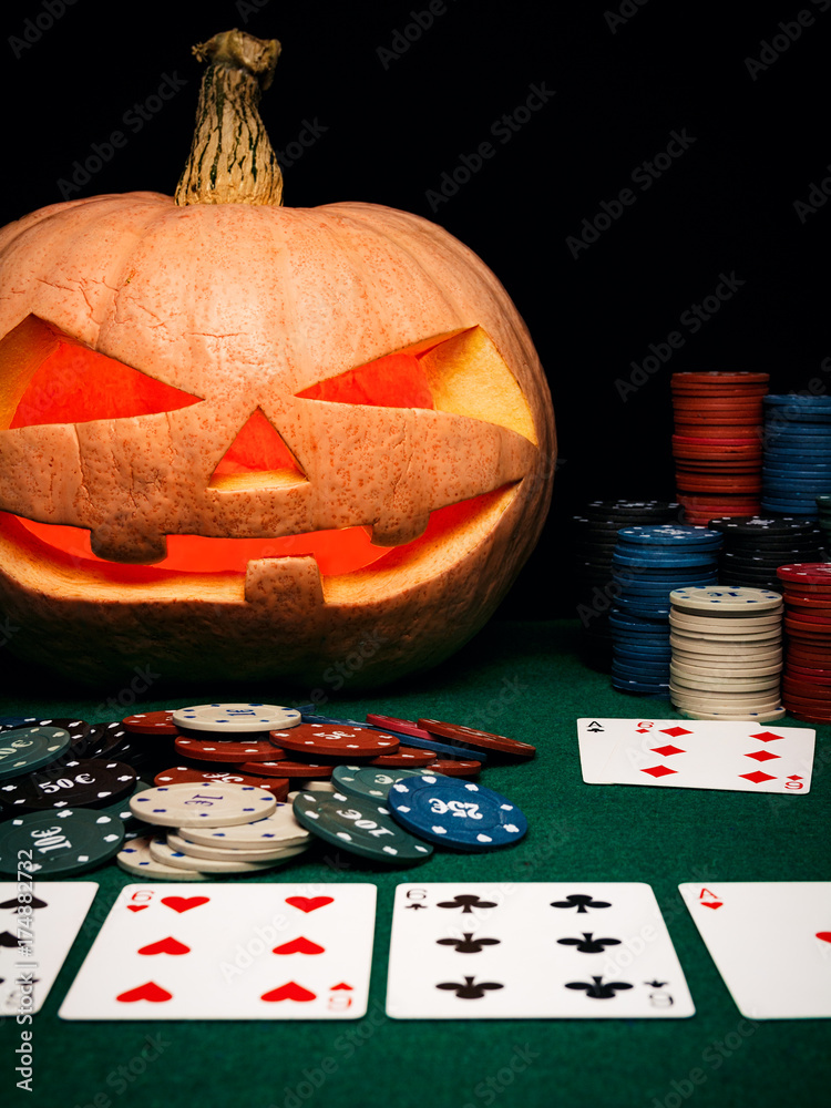 The concept of Halloween. Evil scary pumpkin plays poker. Jack Lantern  among poker chips and cards Stock Photo | Adobe Stock