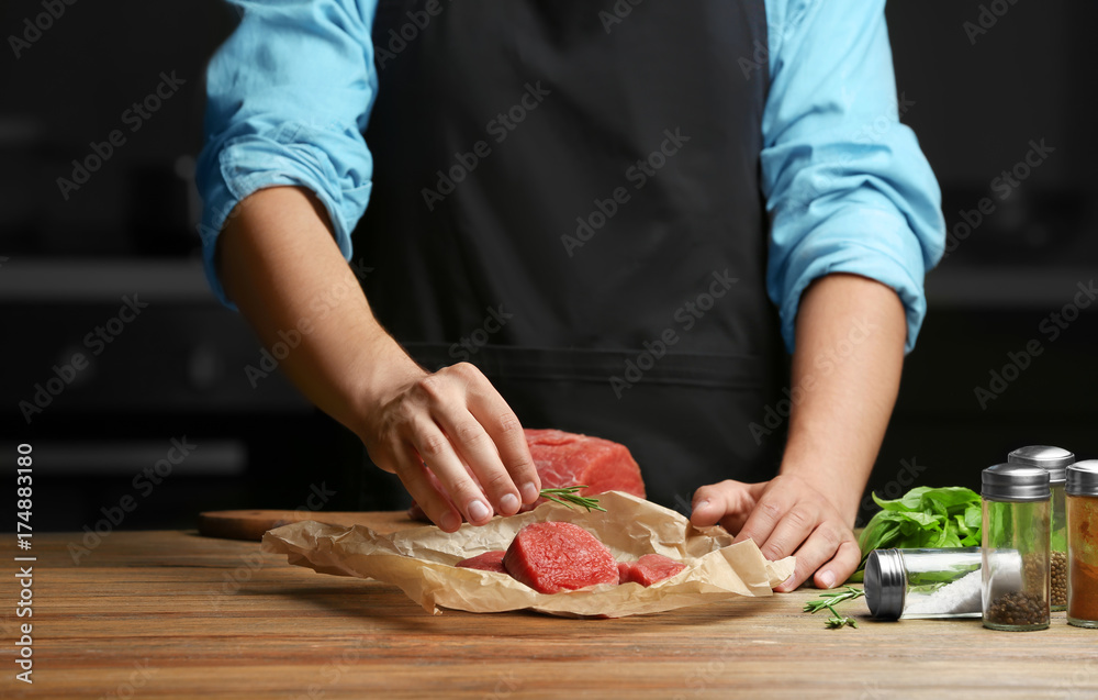 Chef cooking meat on table