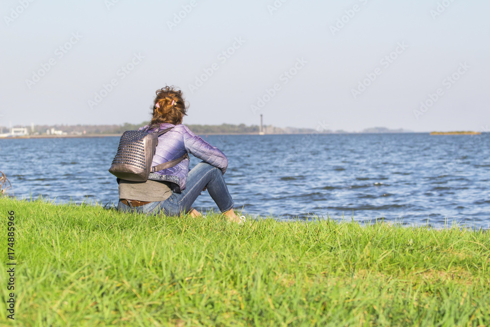 young girl by the sea looking into the distance