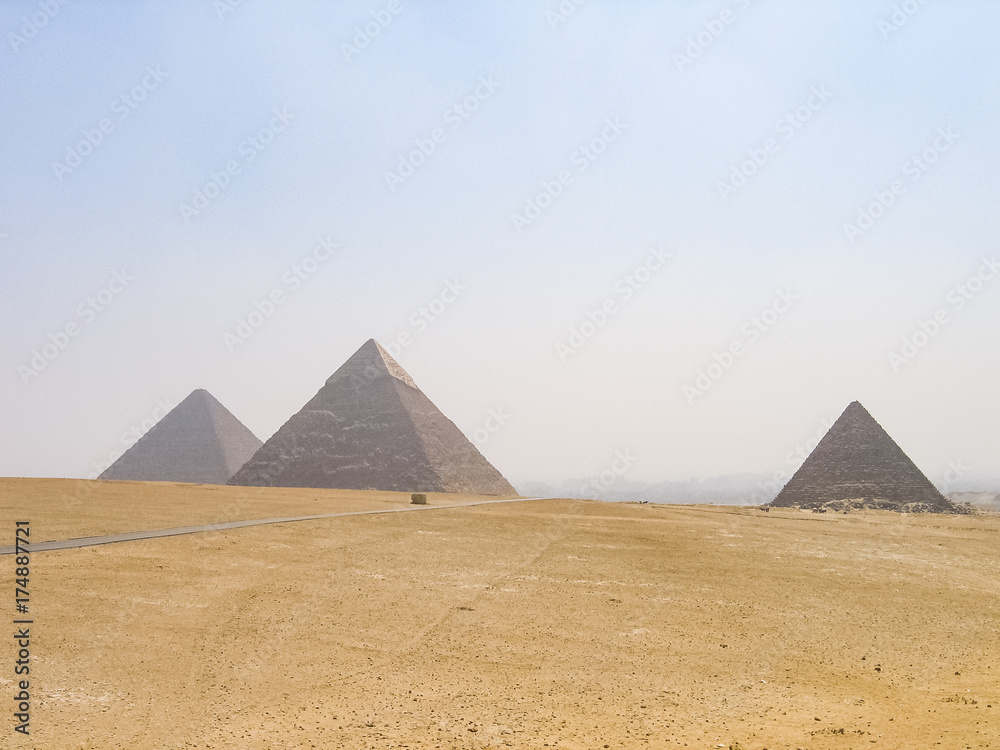 Three pyramids in Giza with road landscape