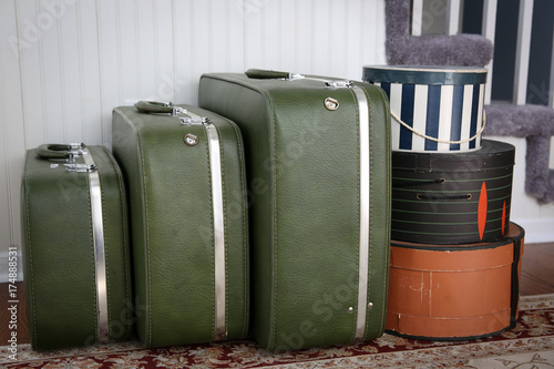Vintage luggage and hatboxes waiting in a foyer.