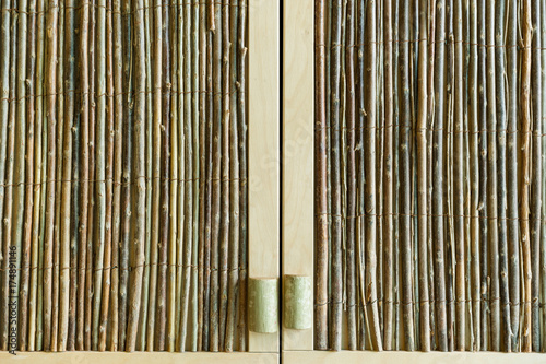 Cabinet doors  made of wood sticks. Background of different types of wood. Thin trees bunches.