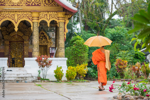 Monk with an umbrella on a city street  Louangphabang  Laos. Copy space for text.