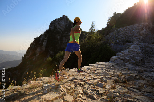  young fitness woman trail runner running on the great wall top of mountain