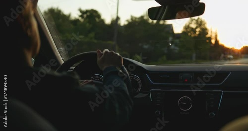 Man Driving a Car at Dusk. SLOW MOTION 4K DCi. Male Hand on steering wheel close up. Beautiful Road in blurred background.