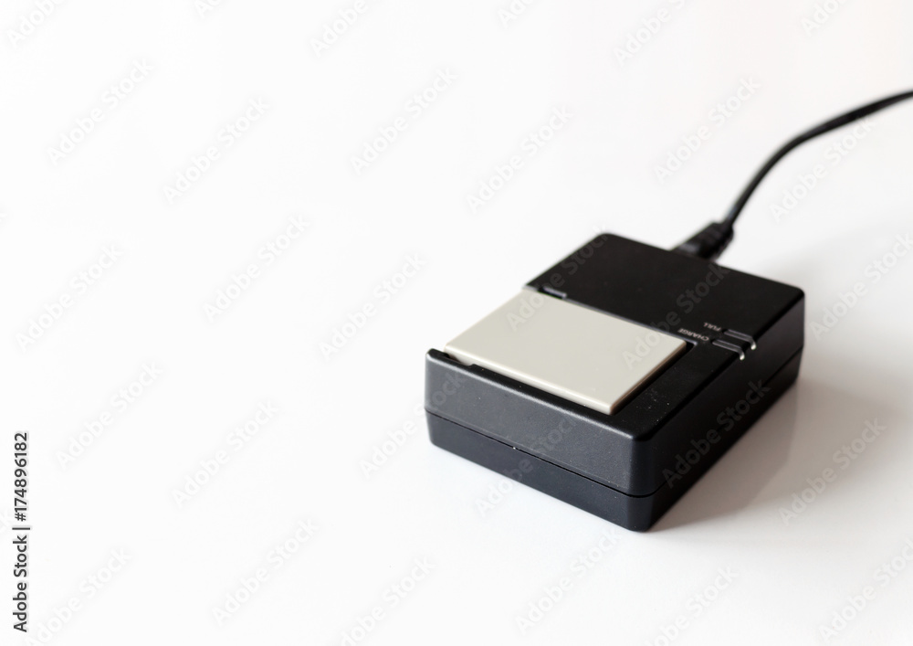 charger for the battery camera with soft-focus and over light in the background charger for the battery camera with soft-focus and over light in the background
