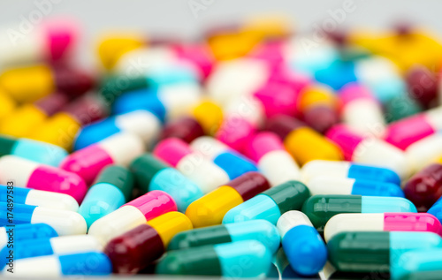 Selective focus of antibiotic capsules pills on blur background, drug resistance concept.